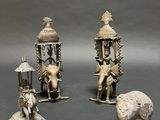 three silver figurines of elephants, a man, and a woman