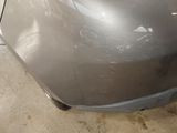 a close up of a car ' s front bumper with a denting on it