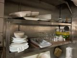 many plates and glasses on the shelves in the kitchen