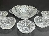 six glass bowls and a bowl on a black surface