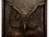 a wooden plaque with an owl on it ' s face