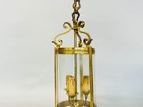 une lanterne ancienne en laiton et en verre, contenant deux bougies