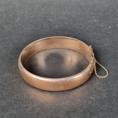 un gros plan sur un bracelet en or entouré d'une chaîne