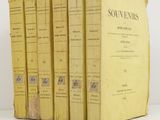 four yellow books sitting on top of each other on a white surface