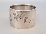 a silver ring with a design on it on a table