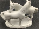 two white horses that are standing on a plate