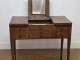 a small wooden table with a mirror on top of it
