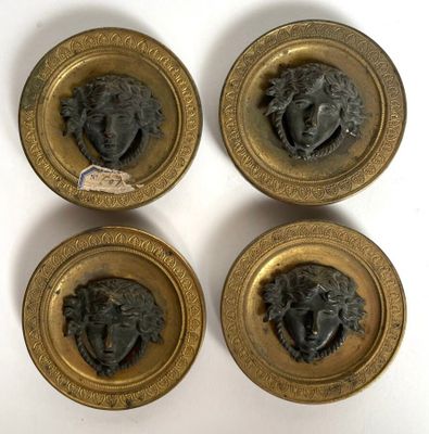four antique brass plaques of a man ' s head and a woman ' s head