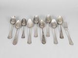 six silver spoons and a fork on a white surface
