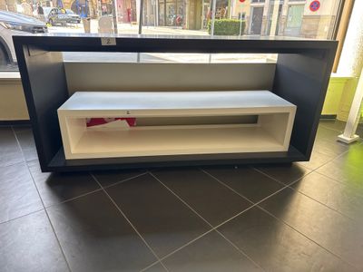 une étagère noire et blanche ornée d'un ruban rouge