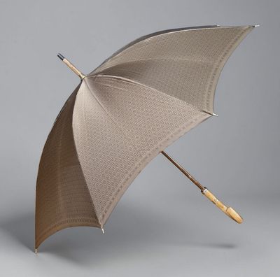 un parapluie ouvert avec un manche en bois sur fond gris