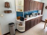 a small kitchen with brown cabinets and a blue backsplash