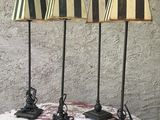 trois lampes noires et blanches posées sur une table recouverte d'une nappe rouge et blanche