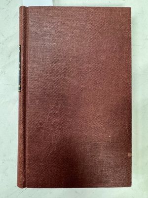 un livre brun posé sur une table blanche