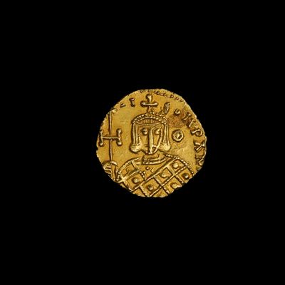 une pièce d'or sur laquelle figure une couronne, sur fond noir