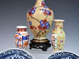 three vases and two bowls sitting on a table