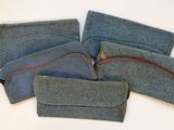 plusieurs morceaux de tissu bleu ornés de coutures rouges, posés sur une surface blanche