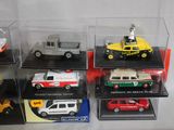 six different models of cars in display cases on a table