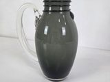 a green glass pitcher sitting on a white table