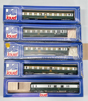quatre trains miniatures dans leurs boîtes, empilés les uns sur les autres