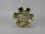 an image of a small green bowl with holes in the center