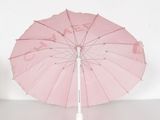 a pink umbrella with a white handle on a white surface