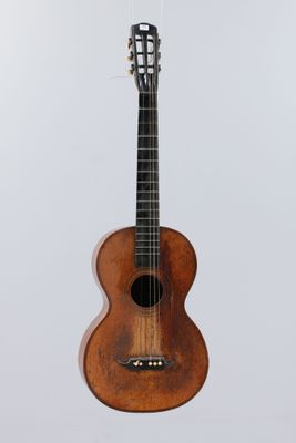 an acoustic guitar hanging from a string on a white background