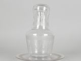a clear glass bottle with a saucer on a saucer