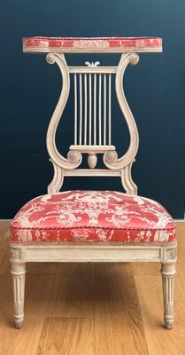 une chaise rouge et blanche posée sur un parquet en bois dur