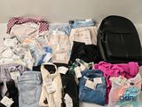 a lot of clothes and a backpack on a table