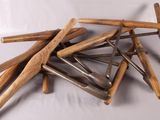 une pile de battes de baseball en bois posées sur une surface blanche
