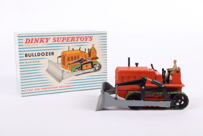 a toy bulldozer and a boxed box on a white surface