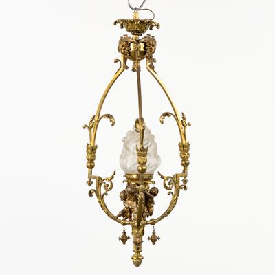 un lustre ancien en laiton, muni d'un abat-jour en verre, suspendu au plafond