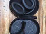 a pair of black headphones in a case on a wooden floor