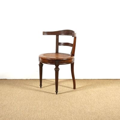une chaise en bois avec une assise en cuir, posée sur un sol recouvert de moquette