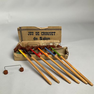 six aiguilles à crocheter en bois dans une boîte, avec un penny en arrière-plan