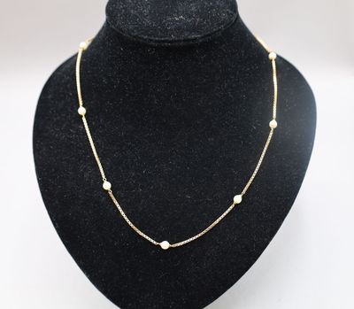 un collier en or orné de perles sur un mannequin noir
