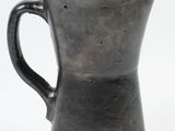 a black pitcher that is sitting on a white surface