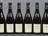 six bottles of wine are lined up in a row on a table