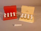 deux flacons de parfum dans un coffret rouge posé sur une table