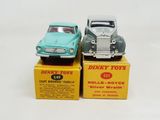 two toy cars sitting on top of boxes on a white surface