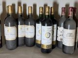 several bottles of wine are lined up in a row on a shelf