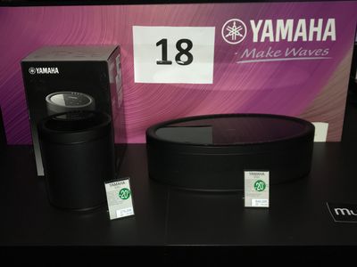 une enceinte noire et une boîte posées sur une table