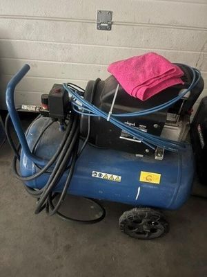 un compresseur d'air bleu sur lequel est posée une serviette rose