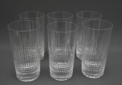 quatre verres transparents sont alignés sur une surface grise