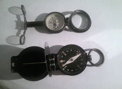 une boussole et une montre de poche posées sur une table