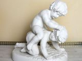 a statue of a boy and a girl on a marble base