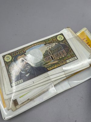 une liasse de billets posée sur une table à côté d'un téléphone portable