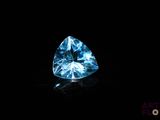 un diamant bleu dans l'obscurité, sur une surface noire