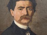 portrait of a man with a mustache in a black suit and white shirt
